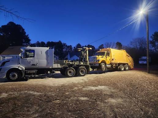 Truck towing sanitation vehicle